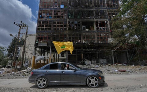 A man with a Hezbollah flag drives past a damaged building following a ceasefire between Israel and Hezbollah in the town of Nabatiyeh, southern Lebanon, June 22, 2026. (AP Photo/Mohammed Zaatari)