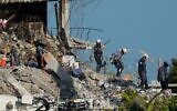 Search and rescue workers descend from the rubble pile at the Champlain Towers South condo building in Surfside, Florida, July 2, 2021. (Mark Humphrey/AP)