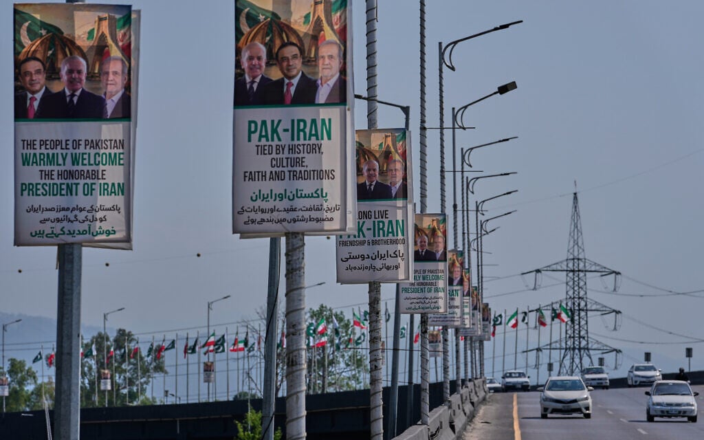 Vehicles drives past welcoming billboards featuring Iranian President Masoud Pezeshkian, right, with Pakistan President Asif Ali Zardari, center, and Shehbaz Sharif alongside an overhead bridge in Islamabad, Pakistan, Tuesday, June 23, 2026. (AP Photo/Anjum Naveed)