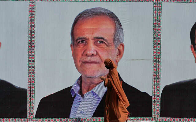 A woman walks past a welcoming billboard featuring Iranian President Masoud Pezeshkian along a roadside in Islamabad, Pakistan, Tuesday, June 23, 2026. (AP Photo/Anjum Naveed)