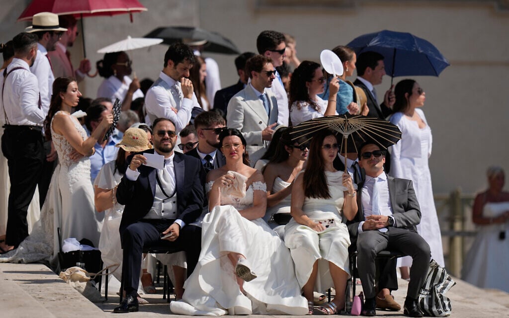 Faithful shelter from the hot sun as they wait for the weekly general audience with Pope Leo XIV in St. Peter's Square at The Vatican on June 24, 2026. (AP Photo/Alessandra Tarantino)