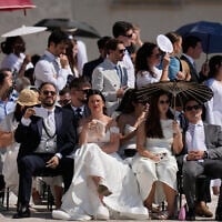 Faithful shelter from the hot sun as they wait for the weekly general audience with Pope Leo XIV in St. Peter's Square at The Vatican on June 24, 2026. (AP Photo/Alessandra Tarantino)