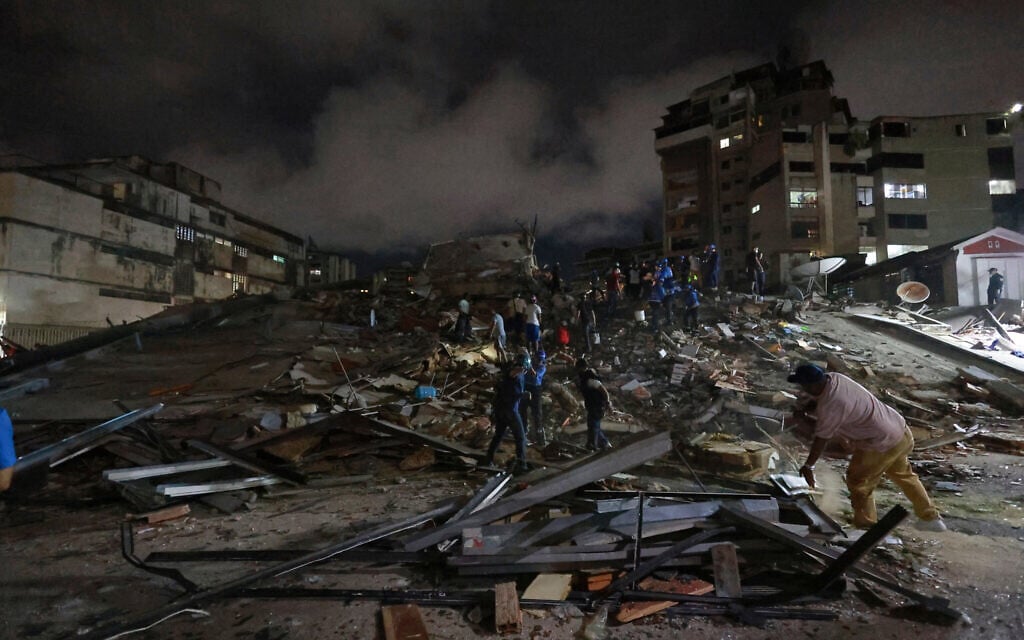 Rescue workers search through the rubble after an earthquake in Caracas, Venezuela, June 24, 2026. (AP Photo/Javier Campos)