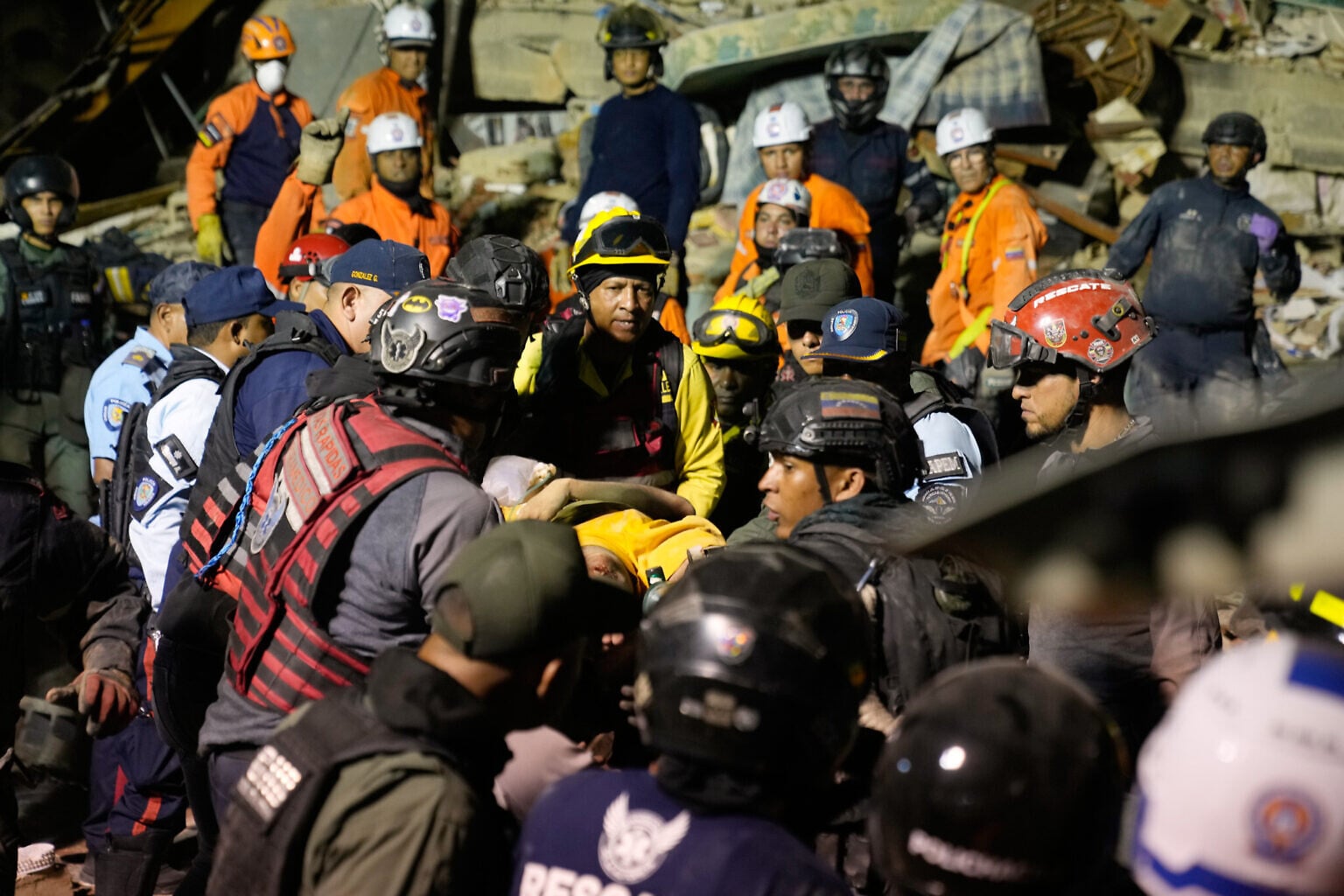 Rescue workers search through the rubble of a collapsed building after two earthquakes in Caracas, Venezuela, June 24, 2026. (AP Photo/Ariana Cubillos)