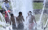 People cool off in a fountain at the Cinquantenaire Park in Brussels, June 25, 2026. (AP/Omar Havana)