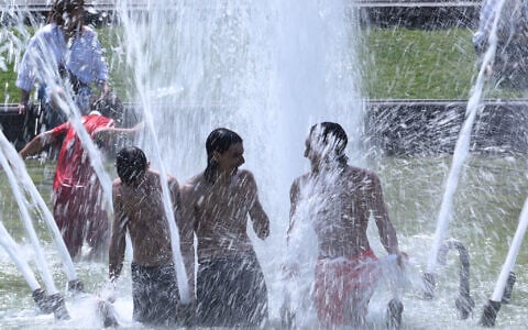 People cool off in a fountain at the Cinquantenaire Park in Brussels, June 25, 2026. (AP/Omar Havana)
