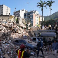 Residents and rescue workers search through the rubble of a building that collapsed in an earthquake in Caracas, Venezuela, June 25, 2026. (AP/Ariana Cubillos)