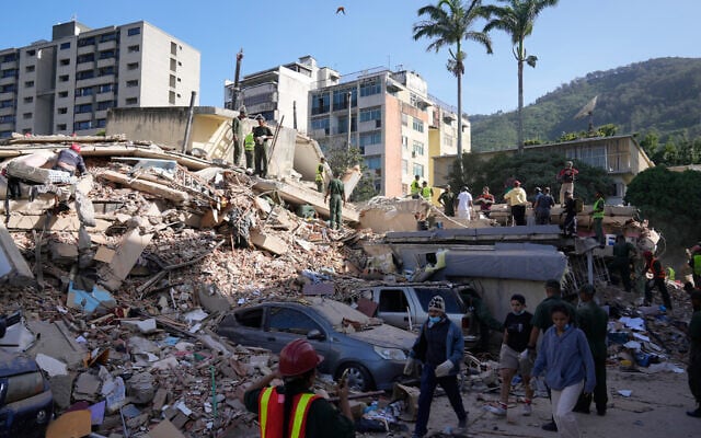 Residents and rescue workers search through the rubble of a building that collapsed in an earthquake in Caracas, Venezuela, June 25, 2026. (AP/Ariana Cubillos)