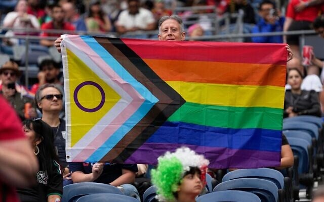 A spectator holds up a Progress Pride flag before the start of the World Cup Group G soccer match between Egypt and Iran in Seattle, Washington, June 26, 2026. (AP Photo//Lindsey Wasson) A spectator holds up a Progress Pride flag before the start of the World Cup Group G soccer match between Egypt and Iran in Seattle, Washington, June 26, 2026. (AP Photo//Lindsey Wasson)