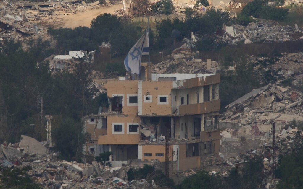An Israeli flag on a destroyed building in southern Lebanon, as seen from northern Israel, June 27, 2026. (AP Photo/Ariel Schalit)