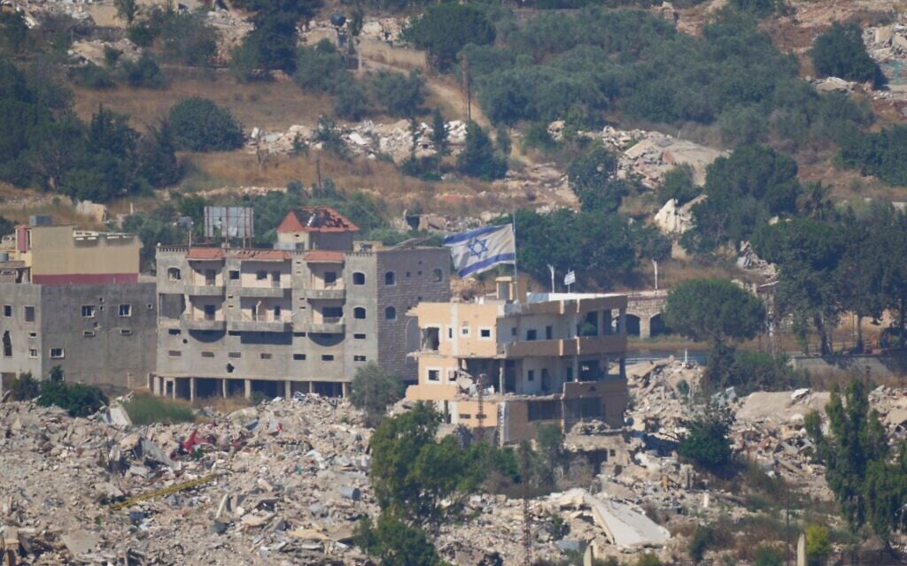 An Israeli flag tops a destroyed building in southern Lebanon, as seen from northern Israel, June 28, 2026. (AP/Ohad Zwigenberg)