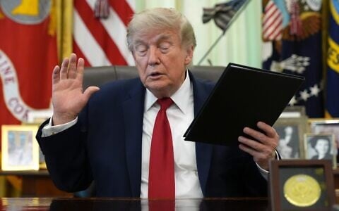 US President Donald Trump holds a signed presidential memo in the Oval Office of the White House, June 29, 2026, in Washington. (AP/Jacquelyn Martin)