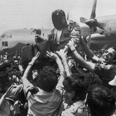 A cheering crowd at Ben-Gurion Airport raises a soldier in the rescue squad that freed the hijacked hostages from Uganda earlier in the day, July 4, 1976. In the background is the C-130 transport plane which took part in the raid. The rescuer's face is obscured for security reasons. (AP Photo/Pool) A cheering crowd at Ben-Gurion Airport raises a soldier in the rescue squad that freed the hijacked hostages from Uganda earlier in the day, July 4, 1976. In the background is the C-130 transport plane which took part in the raid. The rescuer's face is obscured for security reasons. (AP Photo/Pool)