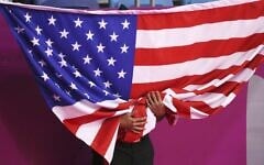 A cadet holds a U.S flag during the medal ceremony of the Men's Individual Taekwondo Poomsae at the Pan American Games in Lima, Peru, Saturday, July 27, 2019 (AP Photo/Fernando Llano)