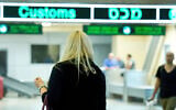 Illustrative: Travelers seen at the arrival hall of Ben Gurion International Airport on April 11, 2018 (Moshe Shai/FLASH90)