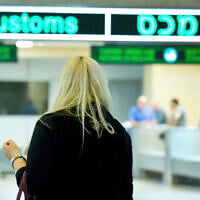 Illustrative: Travelers seen at the arrival hall of Ben Gurion International Airport on April 11, 2018 (Moshe Shai/FLASH90)