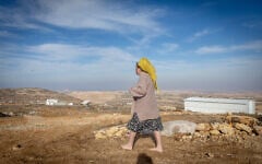 A woman walks near Tzur Misgavi, an illegal outpost in Gush Etzion, in the West Bank, November 17, 2025. (Chaim Goldberg/Flash90)