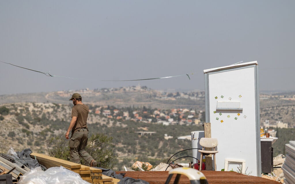 Jewish men build temporary housing units made from shipping containers in the Chavat Meir La’Aretz outpost in the West Bank, March 12, 2026. (Dor Pazuelo/Flash90)