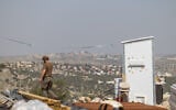 Jewish men build temporary housing units made from shipping containers in the Chavat Meir La’Aretz outpost in the West Bank, March 12, 2026. (Dor Pazuelo/Flash90)