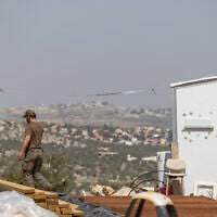 Jewish men build temporary housing units made from shipping containers in the Chavat Meir La’Aretz outpost in the West Bank, March 12, 2026. (Dor Pazuelo/Flash90)