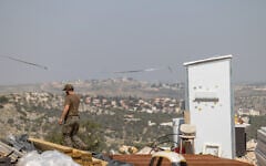 Jewish men build temporary housing units made from shipping containers in the Chavat Meir La’Aretz outpost in the West Bank, March 12, 2026. (Dor Pazuelo/Flash90)