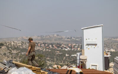 Jewish men build temporary housing units made from shipping containers in the Chavat Meir La’Aretz outpost in the West Bank, March 12, 2026. (Dor Pazuelo/Flash90)