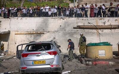 Civilians and security forces at the scene where a missile fired by Hezbollah from Lebanon struck a parking area in Safed, causing heavy damage, April 10, 2026. (David Cohen/Flash90)