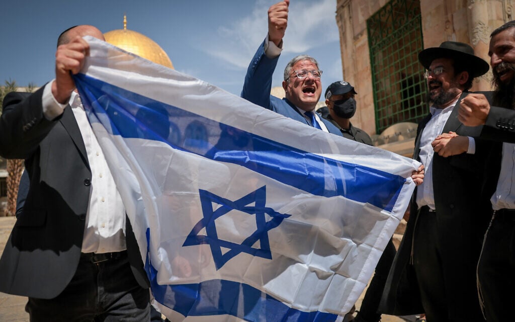 National Security Minister Itamar Ben Gvir waves the Israeli flag as he tours the Temple Mount in Jerusalem's Old City. May 14, 2026. (Yonatan Sindel/FLASH90)
