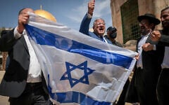 National Security Minister Itamar Ben Gvir waves the Israeli flag as he tours the Temple Mount in Jerusalem's Old City. May 14, 2026. (Yonatan Sindel/FLASH90)