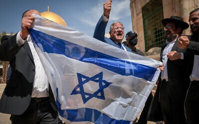National Security Minister Itamar Ben Gvir waves the Israeli flag as he tours the Temple Mount in Jerusalem's Old City. May 14, 2026. (Yonatan Sindel/FLASH90)