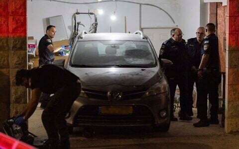 Police inspect a damaged car at the home of Supreme Court Deputy President Noam Sohlberg in the settlement of Alon Shvut, after protesters demonstrated against the imprisonment of yeshiva students who failed to comply with Israeli military recruitment orders, June 3, 2026. (Chaim Goldberg/Flash90)
