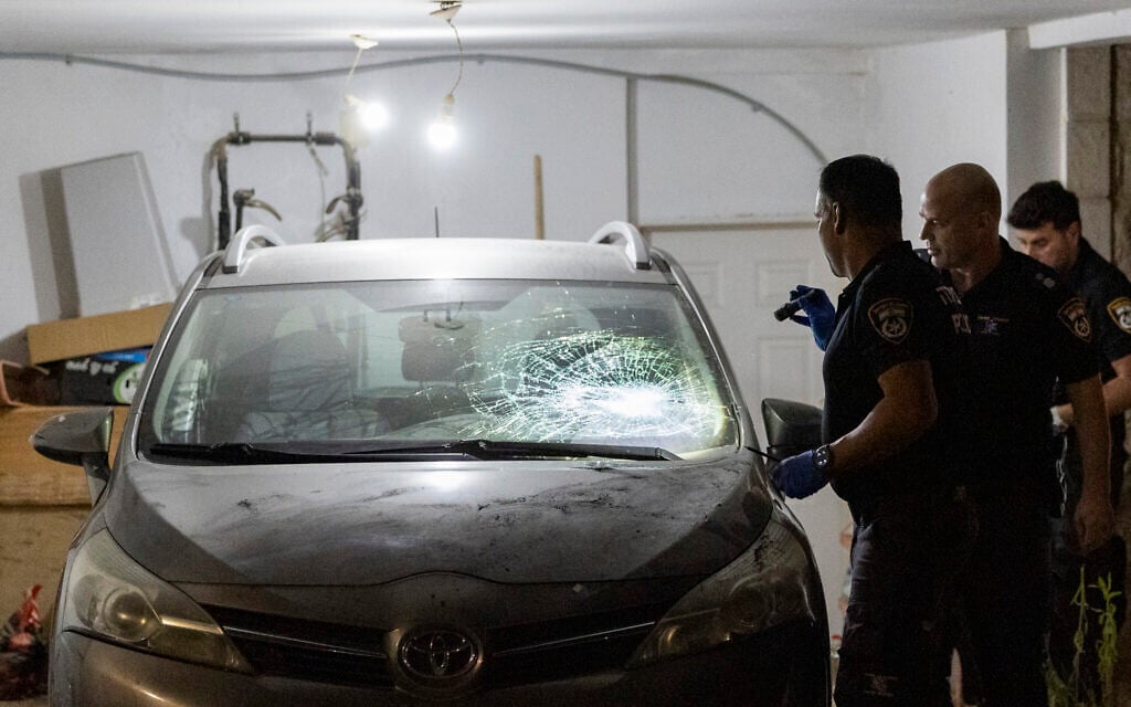 Police inspect a damaged car at the home of Supreme Court Deputy President Noam Sohlberg in the West Bank settlement of Alon Shvut, after ultra-Orthodox Jews attacked the home in protest against the jailing of those who failed to comply with IDF draft orders, June 3, 2026. (Chaim Goldberg/Flash90)