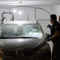 Police inspect a damaged car at the home of Supreme Court Deputy President Noam Sohlberg in the West Bank settlement of Alon Shvut, after ultra-Orthodox Jews attacked the home in protest against the jailing of those who failed to comply with IDF draft orders, June 3, 2026. (Chaim Goldberg/Flash90)