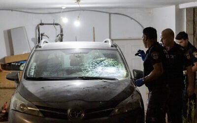 Police inspect a damaged car at the home of Supreme Court Deputy President Noam Sohlberg in the West Bank settlement of Alon Shvut, after ultra-Orthodox Jews attacked the home in protest against the jailing of those who failed to comply with IDF draft orders, June 3, 2026. (Chaim Goldberg/Flash90)
