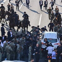 Ultra-Orthodox Jewish men block a road and clash with police during a protest against the jailing of yeshiva students who failed to comply with an army recruitment order, at Ganot Junction near Tel Aviv, June 11, 2026. (Avshalom Sassoni/Flash90)