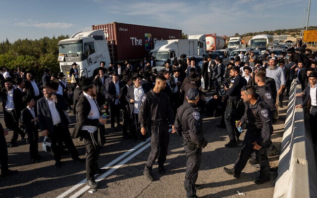 Ultra-Orthodox men block a road and clash with police on Road 6 near the Ben Shemen junction, June 11, 2026. (Yonatan Sindel/Flash90)
