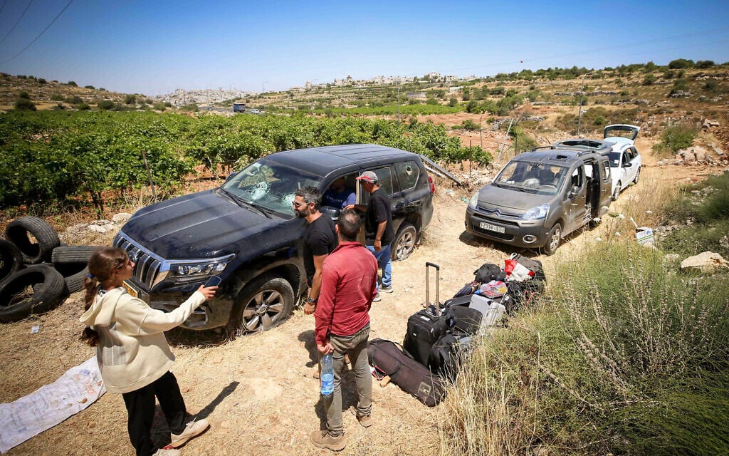 People survey damage caused to Palestinian vehicles by violent settlers who attacked a group of Palestinians and Jewish activists near Halhul, in the Hebron area of the West Bank, on June 15, 2026. (Wisam Hashlamoun/Flash90)