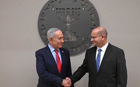 Prime Minister Benjamin Netanyahu, left, shakes hands with new Mossad chief Roman Gofman at a welcoming ceremony, June 2, 2026. (Haim Zach/GPO)