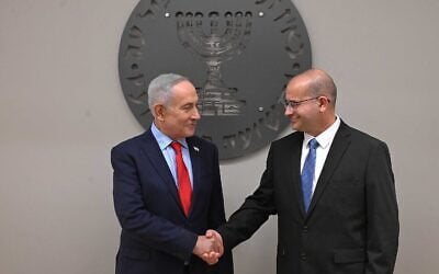 Prime Minister Benjamin Netanyahu, left, shakes hands with new Mossad chief Roman Gofman at a welcoming ceremony, June 2, 2026. (Haim Zach/GPO)