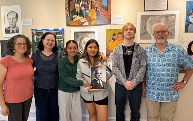 Robin Bigga-Piskernig, second from right, is interning as part of an Austrian program that sends youth abroad to learn and teach about the Holocaust. From left, art teacher Janet Lust Ganes, foundation president Olivia Mattis, two students from Lawrence High School and foundation administrator Matthew Spirn take part in an art exhibit dedicated to Sousa Mendes, a Holocaust rescuer. (Courtesy Sousa Mendes Foundation via JTA)