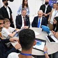 Education Minister Yoav Kisch (left of center) and Prime Minister Benjamin Netanyahu (right of center) sit with students at the Dekel Vilnai Middle School in the settlement of Ma’ale Adumim in the West Bank, to launch an AI-powered English language program on June 11, 2026. (Haim Zach / GPO)
