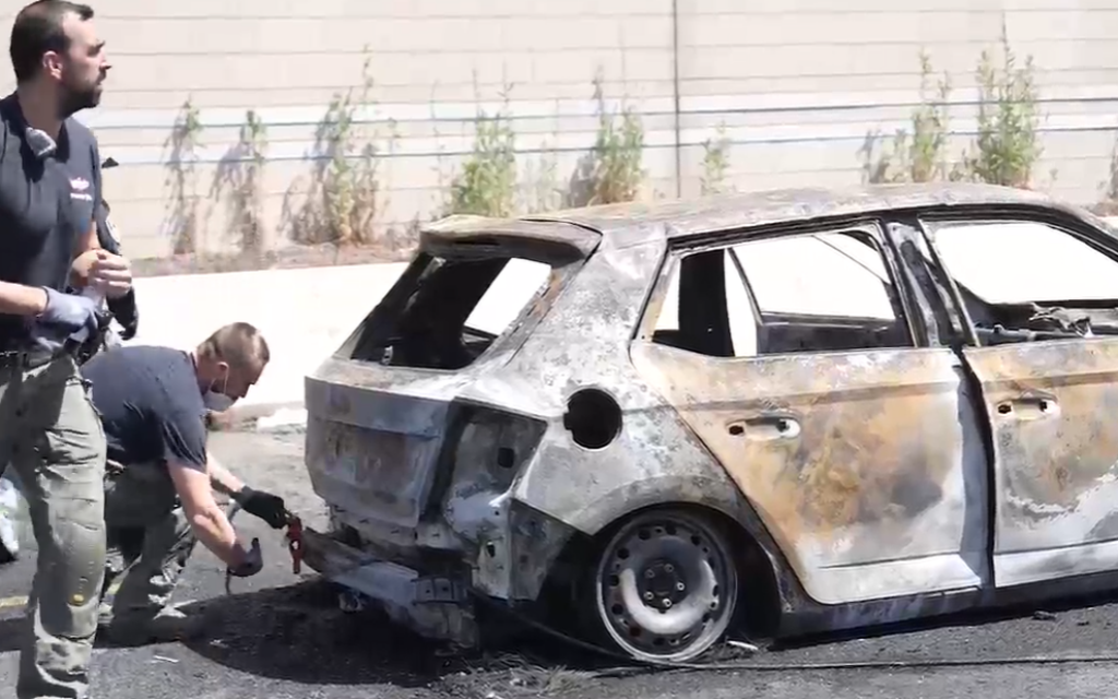 Police officers collect evidence at the scene of a car bombing which left a woman dead in Tel Aviv on June 4, 2026. (Screenshot/Israel Police)