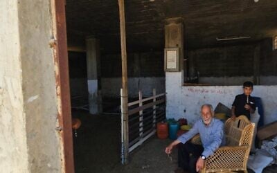 Saeed Odeh alongside another resident of Hawara, at the sheep pen from which he claims settlers stole his livestock. June 7, 2026. (Nurit Yohanan/Times of Israel)