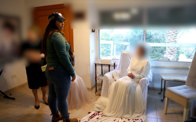 An underage bride interacts with an officer following a police raid on an illegal wedding ceremony in February in Yavne'el, northern Israel (Israel Police) An underage bride interacts with an officer following a police raid on an illegal wedding ceremony in February in Yavne'el, northern Israel (Israel Police)