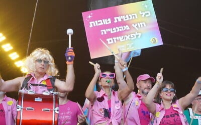 Participants in the annual Pride March walk in a procession to the Knesset in Jerusalem, one holding a sign that reads, "All preferences are good except for the preference for fascism," on June 4, 2026. (Charlie Summers/Times of Israel)
