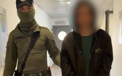 A teenage settler arrested for beating a dog in the West Bank village of Atara being brought into the police station on June 3, 2026.
