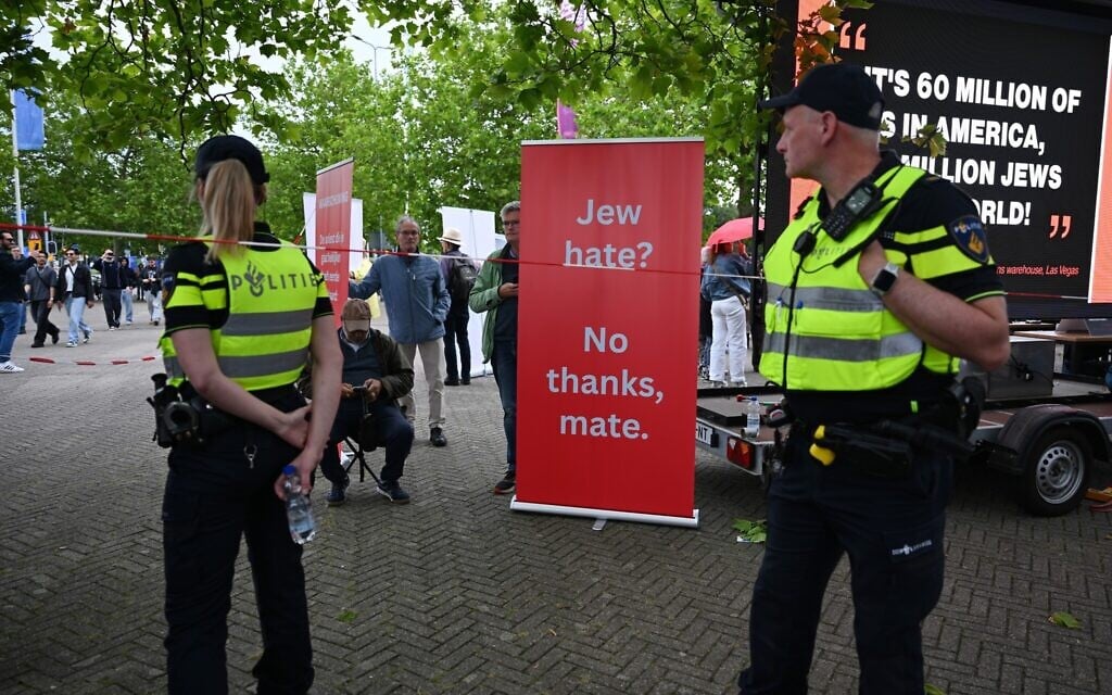 Police patrol as a protestor stands near a banner outside of a venue where Ye, the rapper formerly known as Kanye West, will perform, in Arnhem, Netherlands, June 6, 2026. (Mouneb Taim/AP)