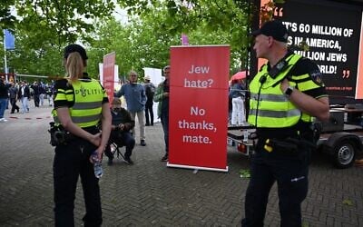 Police patrol as a protestor stands near a banner outside of a venue where Ye, the rapper formerly known as Kanye West, will perform, in Arnhem, Netherlands, June 6, 2026. (Mouneb Taim/AP)