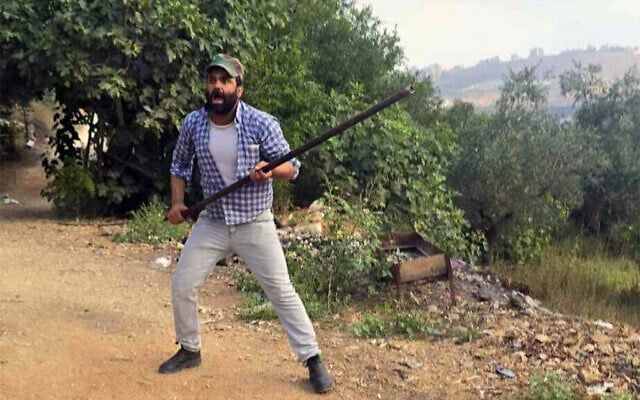 A Palestinian in seen confronting settlers with a pole during a deadly clash near the West Bank village of Tell on July 24, 2026. (Courtesy)