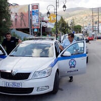 Illustrative: Policemen enter their vehicle on July 23, 2013, in Malia on the Greek island of Crete. (AFP/Costas Metaxakis)
